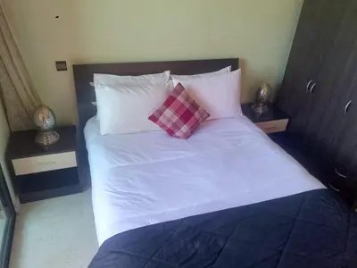 a bed with white sheets and two pillows on it at Appartement au cœur de Gueliz in Marrakech
