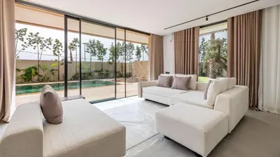 a living room with white furniture and large windows at Villa jardin atlas in Marrakech