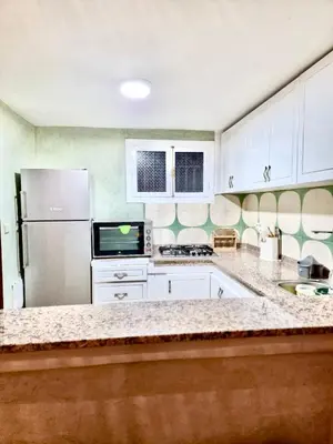 a kitchen with white cabinets and a stainless steel refrigerator at Riad TESS in Marrakech