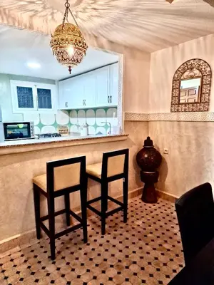 a kitchen with two chairs and a table and a chandelier at Riad TESS in Marrakech