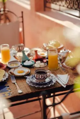 a table with plates of food and glasses of orange juice at Riad TESS in Marrakech