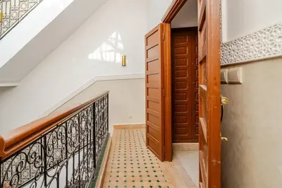 a staircase leading up to a wooden door with a tile floor at Riad TESS in Marrakech