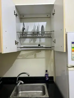 a kitchen with a sink and a shelf with utensils at Cozy Stay Close to Downtown in Marrakech