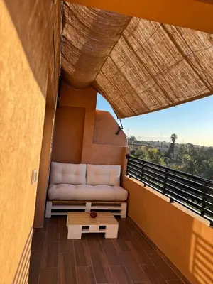 a couch on the balcony of a house at KL Home- au cœur du centre ville moderne in Marrakech