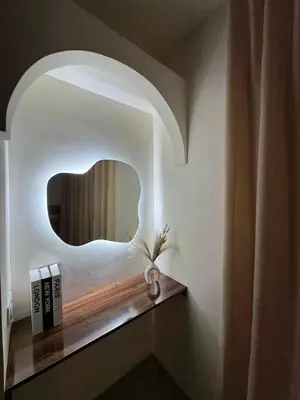 a bathroom with a mirror and a shelf with books at KL Home- au cœur du centre ville moderne in Marrakech