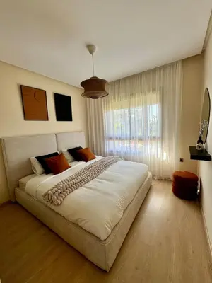 a bedroom with a large bed and a window at Appartement Cosy - vue Piscine - Prestigia JADE in Marrakech