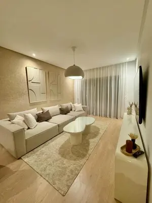 a living room with a white couch and a table at Appartement Cosy - vue Piscine - Prestigia JADE in Marrakech