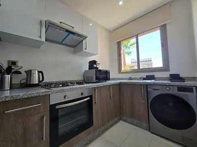 a kitchen with a stove and a dishwasher at Appartement Cosy - vue Piscine - Prestigia JADE in Marrakech