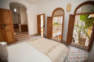 a bedroom with a bed and stained glass doors at Riad Näjma Medina, privatisation, 8 personnes 2 Bassins in Marrakech