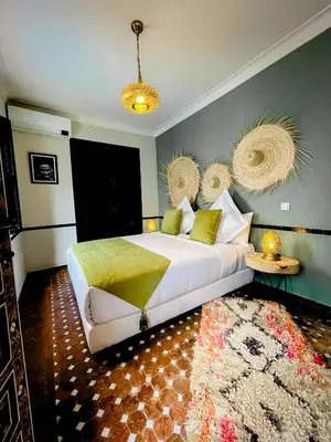 a bedroom with a large bed and a rug at Riad FARASHA in Marrakech