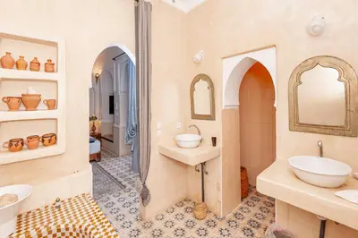 a bathroom with two sinks and two mirrors at Riad GUENAOUA in Marrakech