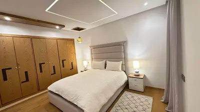 a bedroom with a large bed and wooden cabinets at NEW LUXURY APARTMENT - HEART Of MARRAKECH in Marrakech