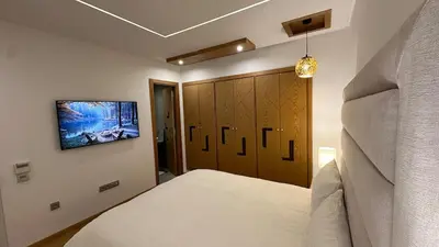 a bedroom with a white bed and a closet at NEW LUXURY APARTMENT - HEART Of MARRAKECH in Marrakech