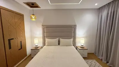 a bedroom with a large white bed with two lamps at NEW LUXURY APARTMENT - HEART Of MARRAKECH in Marrakech
