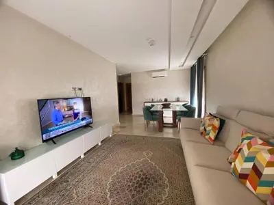a living room with a couch and a flat screen tv at Breathtaking views of golf in Marrakech