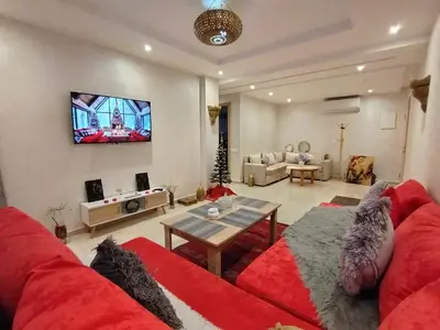 a living room with a red couch and a tv on the wall at Marrakech Luxury ATLAS in Marrakech