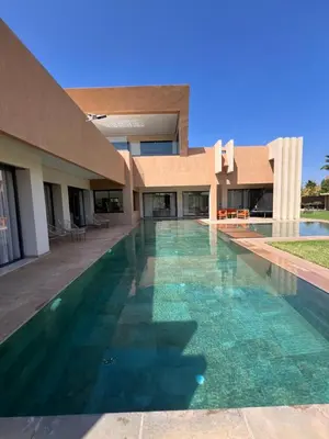 a swimming pool in front of a building at Les Villas de Marrakech in Marrakech