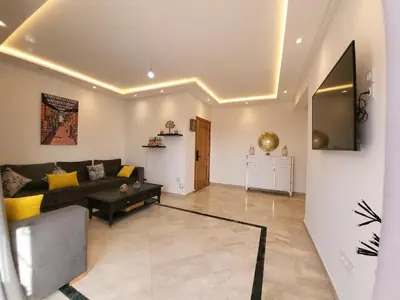 a living room with a couch and a table at Wonderful apartment pool residence Babylon in Marrakech