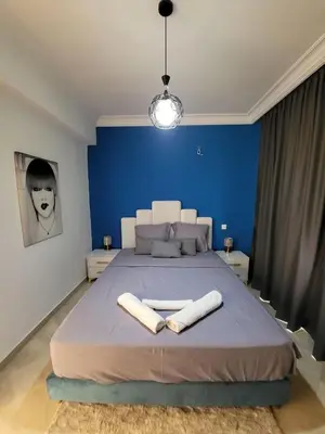 a blue bedroom with a large bed with two towels at Wonderful apartment pool residence Babylon in Marrakech