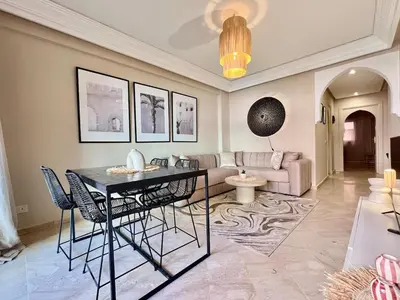 a living room with a table and a couch at Appartement idyllique au centre ville in Marrakech