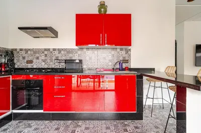 a red kitchen with black counters and red cabinets at Villa Slimani in Marrakech