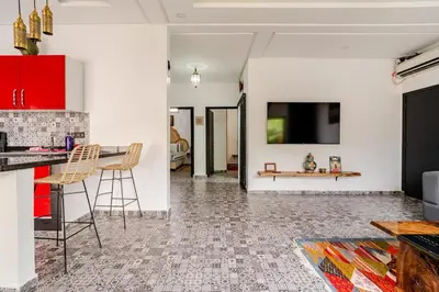 a kitchen with a table and a tv on a wall at Villa Slimani in Marrakech