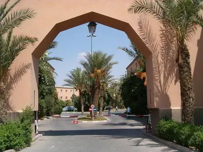 an archway leading to a street with palm trees at Appartement in Marrakech
