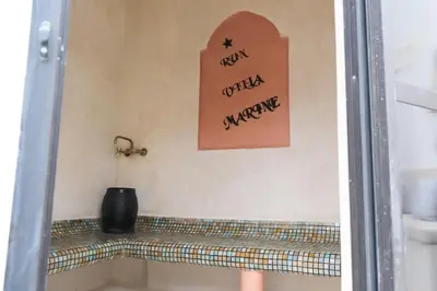 a bathroom with a bath tub with a sign on the wall at Elegant Marrakech Villa with Optional Heated Pool for Ultimate Relaxation in Touggana