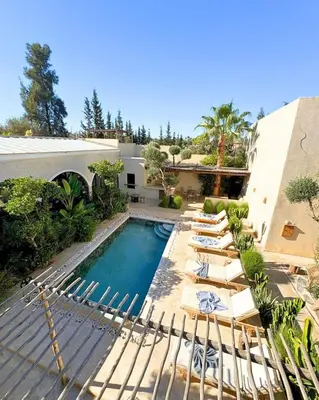 a swimming pool with lounge chairs and a house at Run Villa Marine, Elegant Private Villa in Marrakech with Heated Pool Option in Marrakech