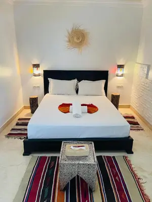 a bedroom with a large bed and a table at Run Villa Marine, Elegant Private Villa in Marrakech with Heated Pool Option in Marrakech