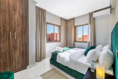 a bedroom with a bed and some windows at Cocon Chaleureux au Cœur de la Ville in Marrakech