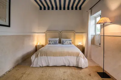 a bedroom with a white bed with two pillows at Dar Babette in Marrakech