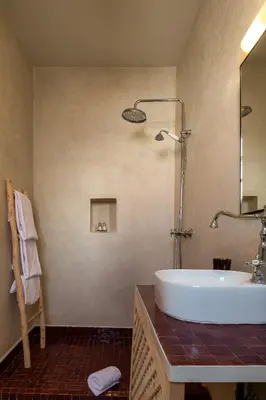 a bathroom with a sink and a mirror and a tub at Dar Babette in Marrakech