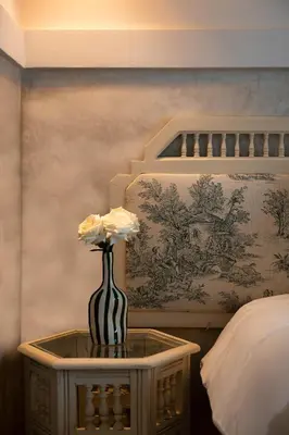 a vase with flowers on a table in a bedroom at Dar Babette in Marrakech