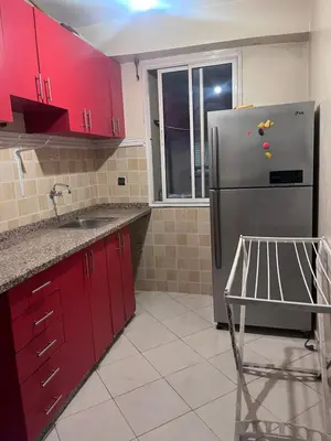 a kitchen with red cabinets and a stainless steel refrigerator at Yassmirouaq in Marrakech