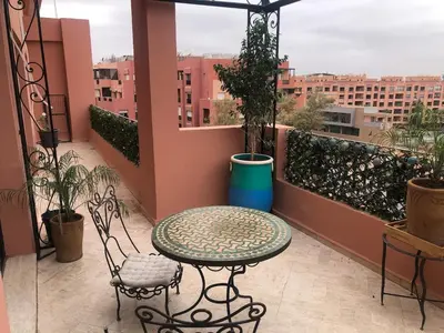 a balcony with a table and chairs on a balcony at Wonderful apartment pool residence Babylon 2- chambre in Marrakech