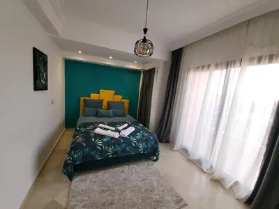 a bedroom with a bed and a green wall at Wonderful apartment pool residence Babylon 2- chambre in Marrakech