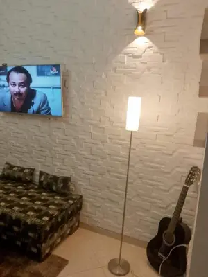 a living room with a couch and a guitar at Bel appartement moderne in Marrakech