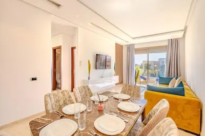 a dining room with a table and chairs and a couch at New! Appt Moderne Jubaea avec parking & wifi in Marrakech