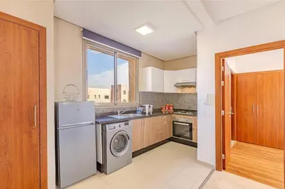 a kitchen with a washer and dryer and a window at New! Appt Moderne Jubaea avec parking & wifi in Marrakech