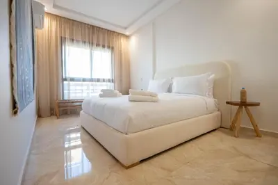 a bedroom with a large white bed with a window at Hivernage by Louhou Collection in Marrakech