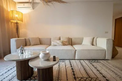 a living room with a couch and two tables at Hivernage by Louhou Collection in Marrakech