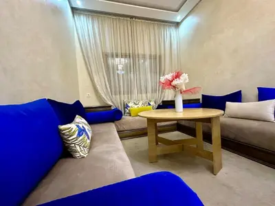 a living room with a blue couch and a table at Comfort and Charm in Marrakech 6 min from Gueliz in Marrakech