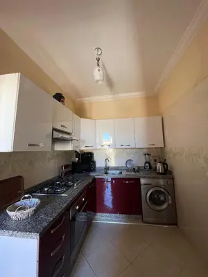 a kitchen with white cabinets and a washing machine at Abwab guilize Beautiful modern apartment in Marrakech