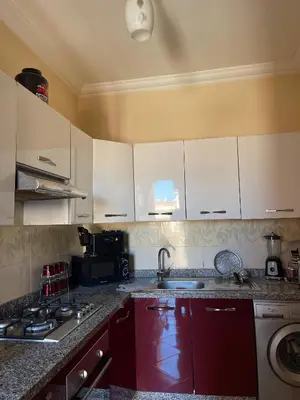 a kitchen with white cabinets and a sink at Abwab guilize Beautiful modern apartment in Marrakech