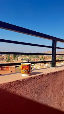 a coffee cup sitting on the ledge of a balcony at Welcome to Chya House! in Marrakech