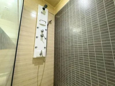 a shower in a bathroom with a tile wall at Gueliz Marrakech Private 2BR Apartment with Pool and Parking in Marrakech