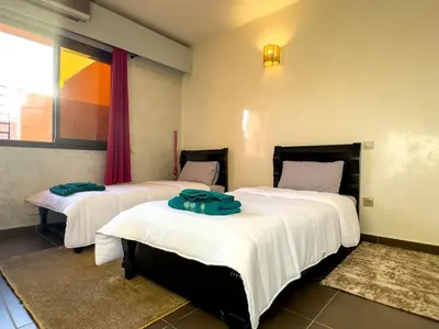 a bedroom with two beds with white sheets and a window at Gueliz Marrakech Private 2BR Apartment with Pool and Parking in Marrakech