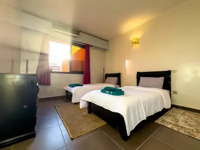 a hotel room with two beds and a window at Gueliz Marrakech Private 2BR Apartment with Pool and Parking in Marrakech