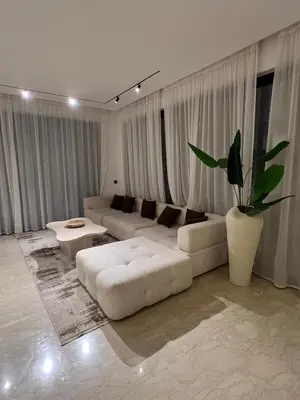 a white living room with a white couch and a plant at Dar Zohra in Marrakech